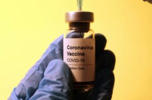 Coronavirus-Impfung vor gelbem Hintergrund, Credit: Hakan Nural, Unsplash
