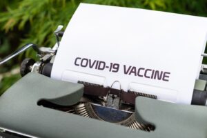 Schreibmaschine mit weißem Blatt Papier, Text: COVID-19 VACCINE. Photo by Markus Winkler on Unsplash