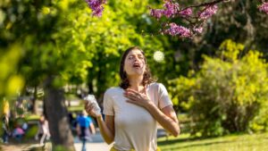 Frau niest im Freien, Credit: Canva